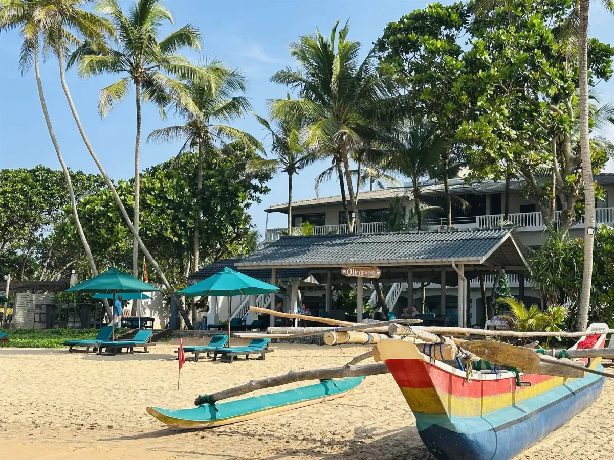 Suite Lanka beachfront exterior with a traditional fishing boat